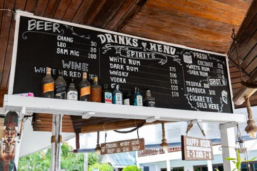 a blackboard with bottles of beer on a bar at Tiki Beach Koh Phangan Beach Restaurant Bar and Coworking in Ban Tai
