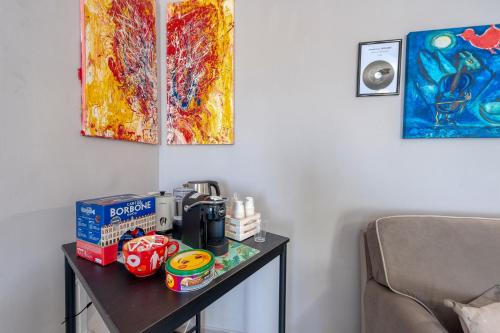 a table with a coffee maker and a painting on the wall at Meravigliosalento in Squinzano