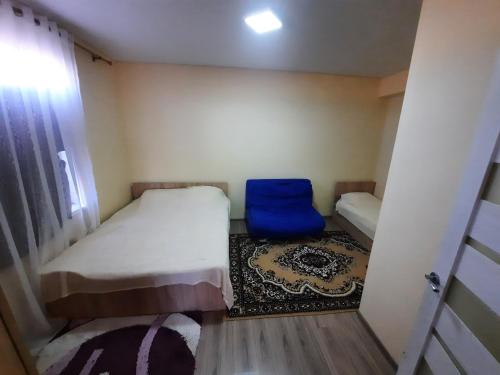 a small room with two beds and a blue chair at Guest House SALUTE in Kaji-Say