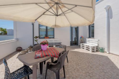 a patio with a table and a large umbrella at Meravigliosalento in Squinzano