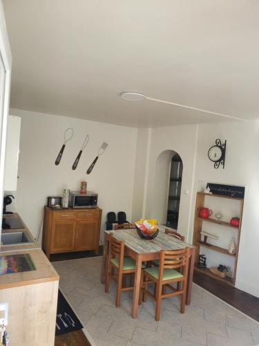 une cuisine avec une table et des chaises dans une pièce dans l'établissement Charmante Petite Maison Audoise, à Trausse