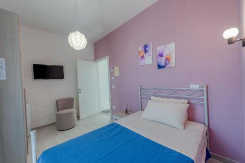 a bedroom with a bed and a purple wall at Meravigliosalento in Squinzano