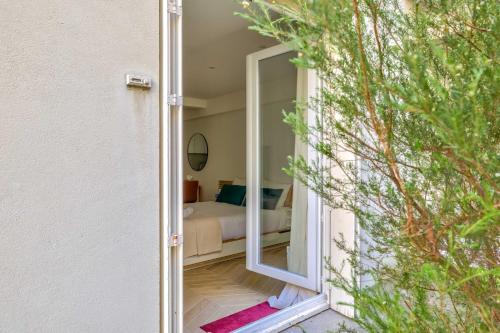 - une porte menant à une chambre avec un lit et un miroir dans l'établissement Superb Studio bien équipé Paris Montparnasse, à Paris