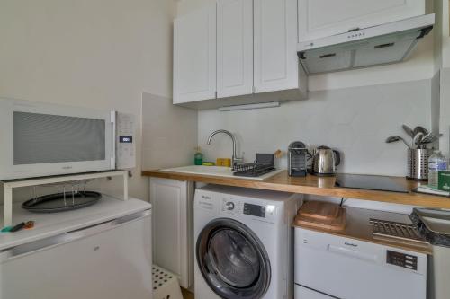 une cuisine avec un lave-linge et un micro-ondes dans l'établissement Superb Studio bien équipé Paris Montparnasse, à Paris