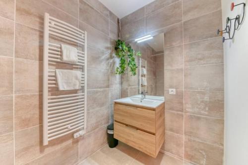 une salle de bain avec un lavabo et une douche aux murs carrelés dans l'établissement Appartement 72 m² avec jardin 100 m² - 2 chambres, à Saint-Cyr-au-Mont-dʼOr