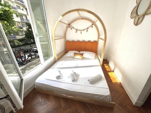un petit lit dans une chambre avec une fenêtre dans l'établissement ApartHotel Riviera - TERRASSE HORIZON - 15' Promenade des Anglais, à Nice