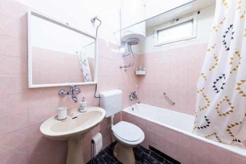 a pink bathroom with a sink and a toilet and a tub at Casa Tradizionale Volosko in Opatija