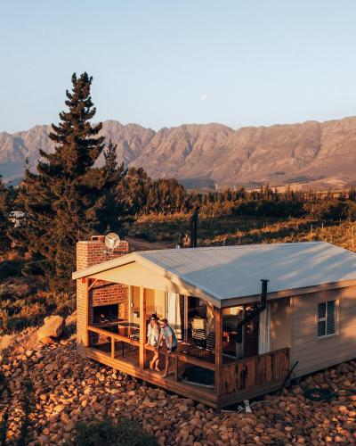 two people standing on the porch of a tiny house at Kingfisher Cabin at Vrolikheid Landgoed in Tulbagh
