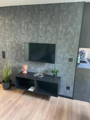 a black entertainment center with a flat screen tv on a wall at RHE036-008 Apartment Bremerhaven in Bremerhaven