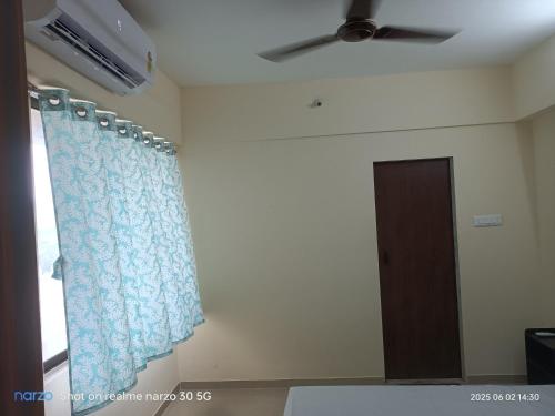a room with a ceiling fan and a window with a curtain at Private Room At Pushpanjali Residency Phase 3 S1 Block Ovale Ghodbunder Road Thane West in Thane