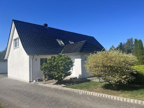 a white house with a black roof at Ferienwohnung auf zwei Ebenen mit Terrasse in Gägelow