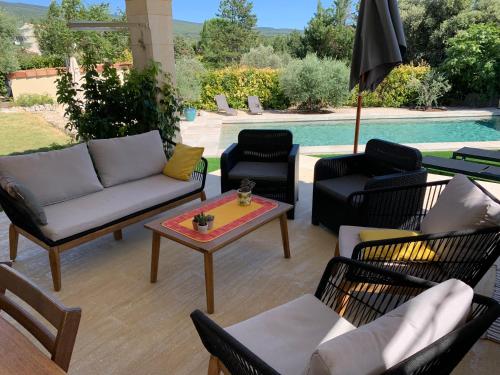 une terrasse avec des chaises, une table et une piscine dans l'établissement Les Hauts Sauviers, à Bédoin