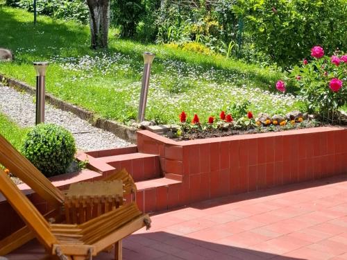 a bench in a garden with flowers and plants at Villa Anni in Sarajevo