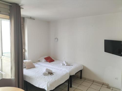 Cette chambre comprend 2 lits jumeaux et une télévision. dans l'établissement Résidence Graziella Studio 408, à Juan-les-Pins