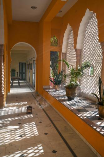 an empty hallway of a house with potted plants at Diggi Palace - A City Center Hidden Heritage Gem in Jaipur