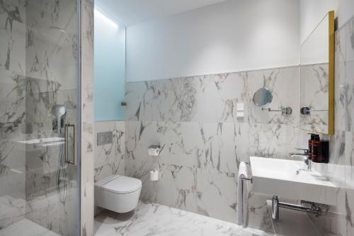 a bathroom with a toilet and a sink and a shower at Áurea Ana Palace by Eurostars Hotel Company in Budapest