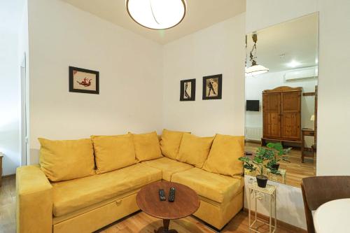 una sala de estar con un sofá y una mesa en Wehost Heart Of Tbilisi Studio, en Tiflis