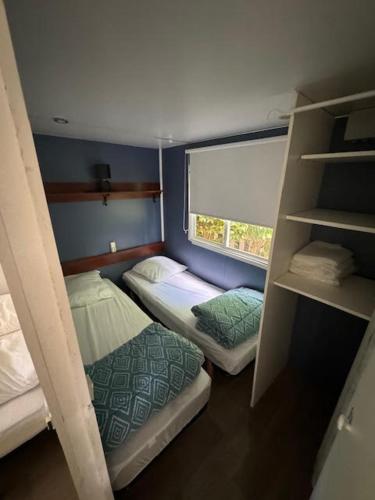 une petite chambre avec deux lits superposés et une fenêtre dans l'établissement europcamping 22 m2, à Fréjus