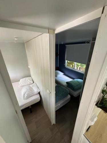 une petite chambre avec deux lits et une fenêtre dans l'établissement europcamping 22 m2, à Fréjus