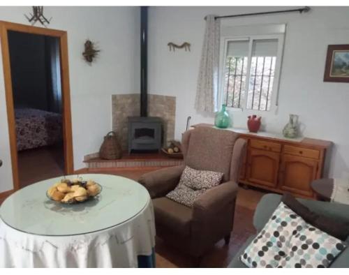 a living room with a table and a chair at Welcoming chalet with lake and mountain view - El Gastor in El Gastor