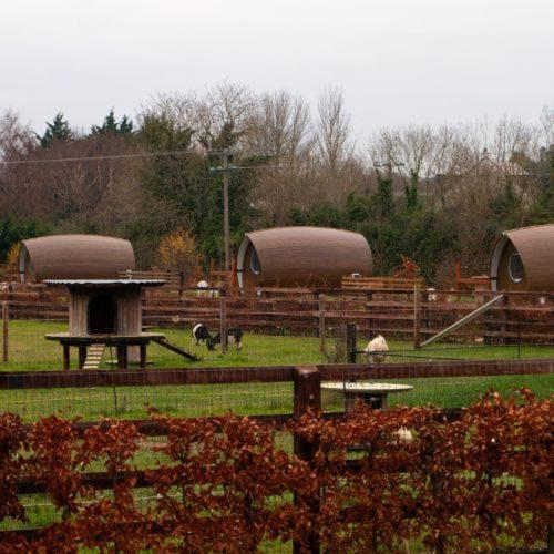 a farm with a fence and a picnic table and buildings at Hidden Acres- Luxury Glamping Pod Mint in Malahide