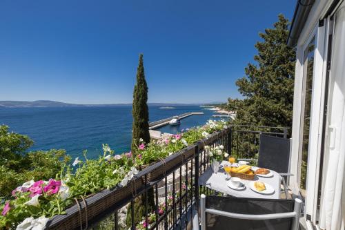 a balcony with a table and a view of the ocean at Mitan Accommodation in Novi Vinodolski
