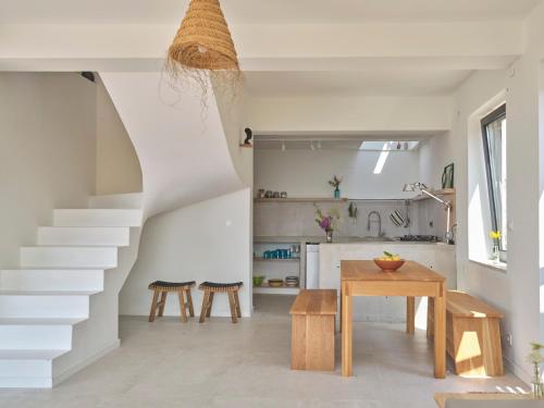 a kitchen and dining room with a staircase and a table at Vigla Paxos in Lákka