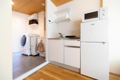 a kitchen with white cabinets and a refrigerator at Ueno-an 4,5F in Tokyo