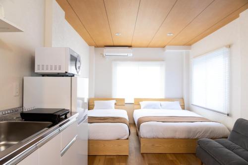 a small room with two beds and a kitchen at Ueno-an 4,5F in Tokyo