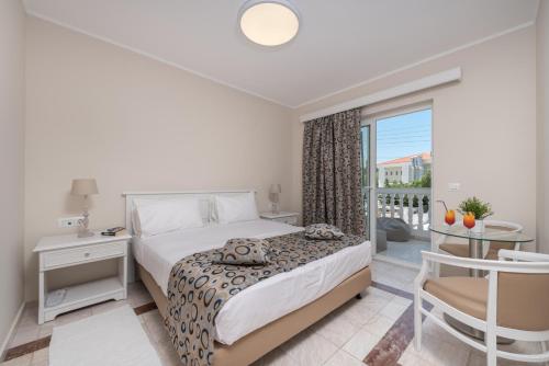 a bedroom with a bed and a balcony at Zante Park Resort & Spa BW Premier Collection in Laganas
