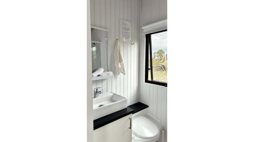a white bathroom with a sink and a window at Hill River Nature Reserve by Tiny Away in Jurien Bay