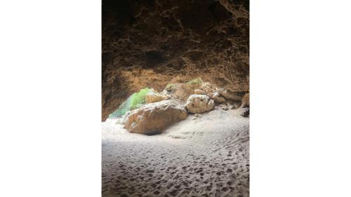 a group of rocks on a sandy beach at Hill River Nature Reserve by Tiny Away in Jurien Bay