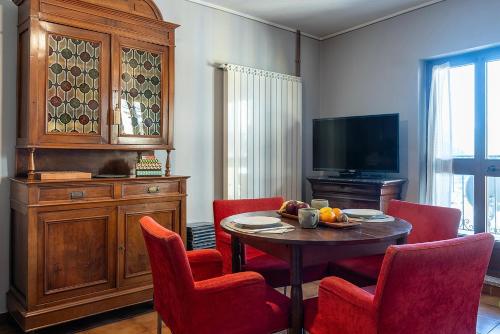 a living room with a table and chairs and a television at Dagli Olivari - Casa Ale in Gromo