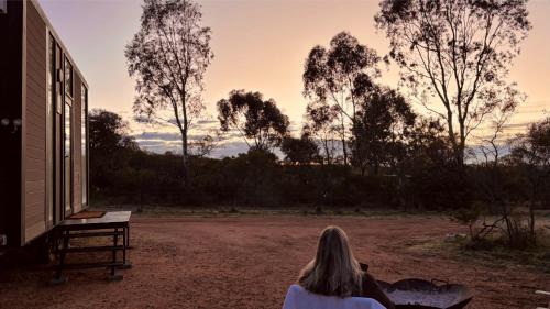 a woman sitting on a bench watching the sunset at Hill River Nature Reserve by Tiny Away in Jurien Bay