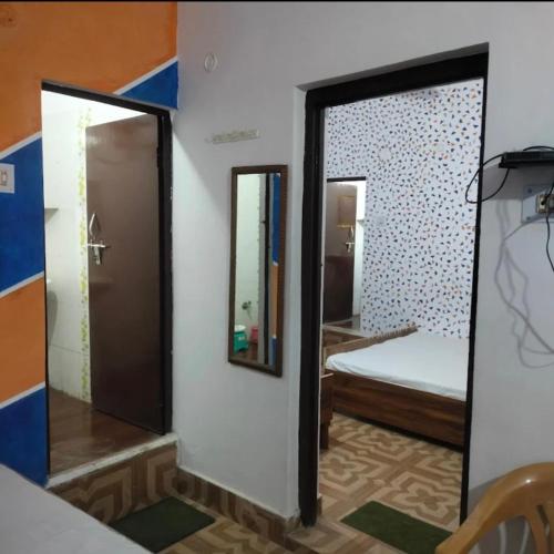 a bedroom with a mirror and a bed in a room at Kanhaiya Home Stay Guptkashi Kedarnath Road in Gupta Kāshi