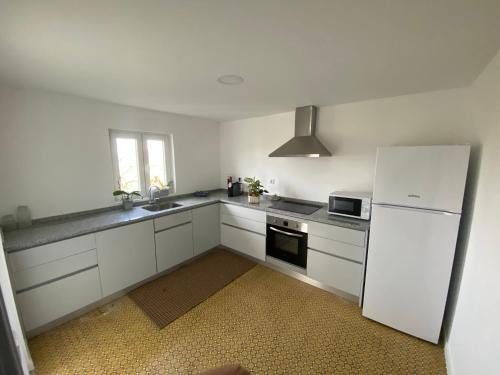 una cucina con mobili bianchi e un frigorifero bianco di Casa do Avô Gil a Seixo