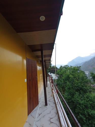 a yellow building with a wooden door on a balcony at Kanhaiya Home Stay Guptkashi Kedarnath Road in Gupta Kāshi
