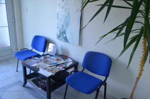 two blue chairs and a table in a room at Villa Ladver in Hévíz