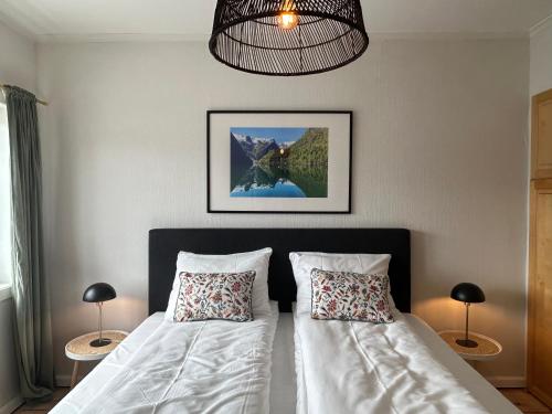 a bedroom with two beds and a chandelier at Sognefjord Gjesteheim in Vangsnes