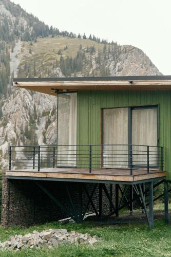 a green house with a deck on a mountain at Pana Unique Kolsay in Kurmenty