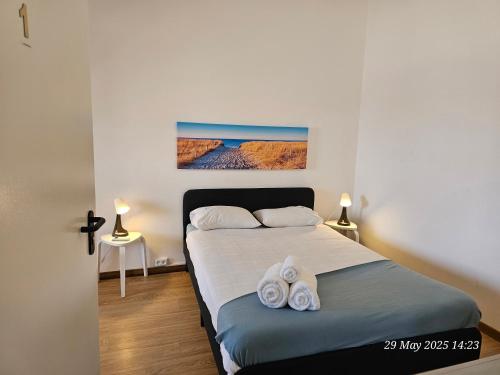 a bedroom with a bed with towels on it at Blife Bandaya private rooms at Faro beach in Faro
