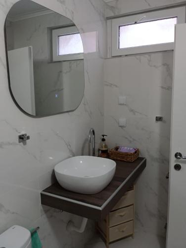 a bathroom with a white sink and a mirror at Polixniati's House in Polichnítos