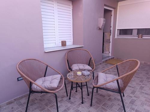 a patio with two chairs and a table and a window at Polixniati's House in Polichnítos
