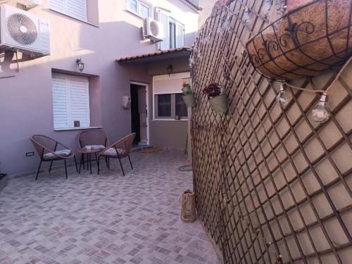 a wall with chairs and a table in a courtyard at Polixniati's House in Polichnítos