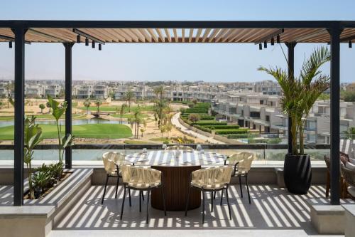 a table and chairs on a balcony with a view at The G Einbay Golf Resort in Ain Sokhna