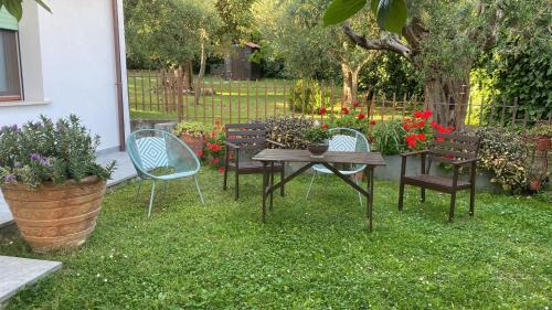 a table and chairs in a yard with flowers at Casa vacanze Coke in Passignano sul Trasimeno