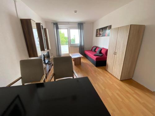 a living room with a red couch and a table at Elb Apartment in Magdeburg