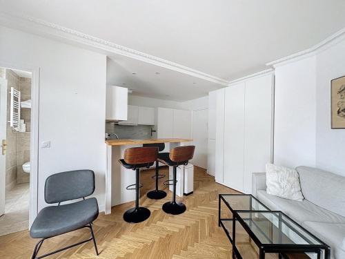 un salon avec un canapé, une table et des chaises dans l'établissement Paris 8 Madeleine beauty, à Paris