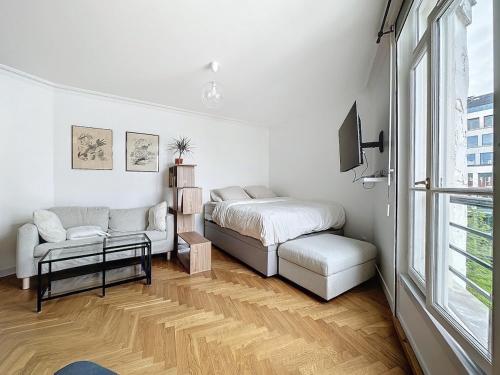une chambre avec un lit, un canapé et une fenêtre dans l'établissement Paris 8 Madeleine beauty, à Paris