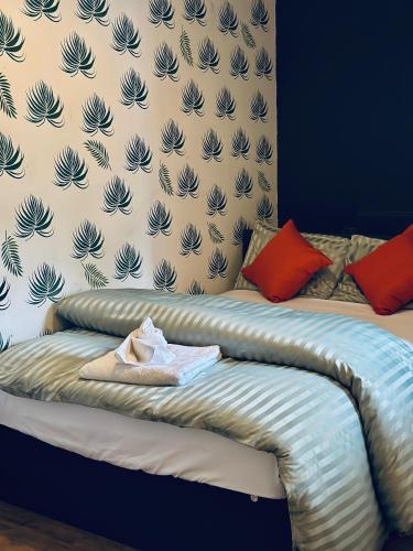 a bed with a blanket and some pillows and a wall at Parkend Room stay in city centre oxford in Oxford